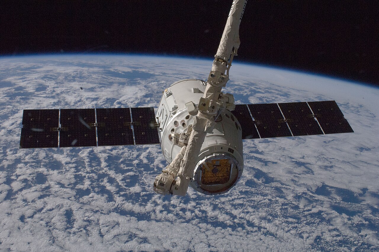 Statek towarowy Dragon firmy SpaceX jest przechwytywany przez ramię Canadarm2 Międzynarodowej Stacji Kosmicznej podczas misji SpaceX CRS-1, 10 października 2012 r. Zdjęcie archiwalne; nie przedstawia opisywanego zdarzenia Plik bez zmian redakcyjnych; miniatura dopasowana do układu strony.